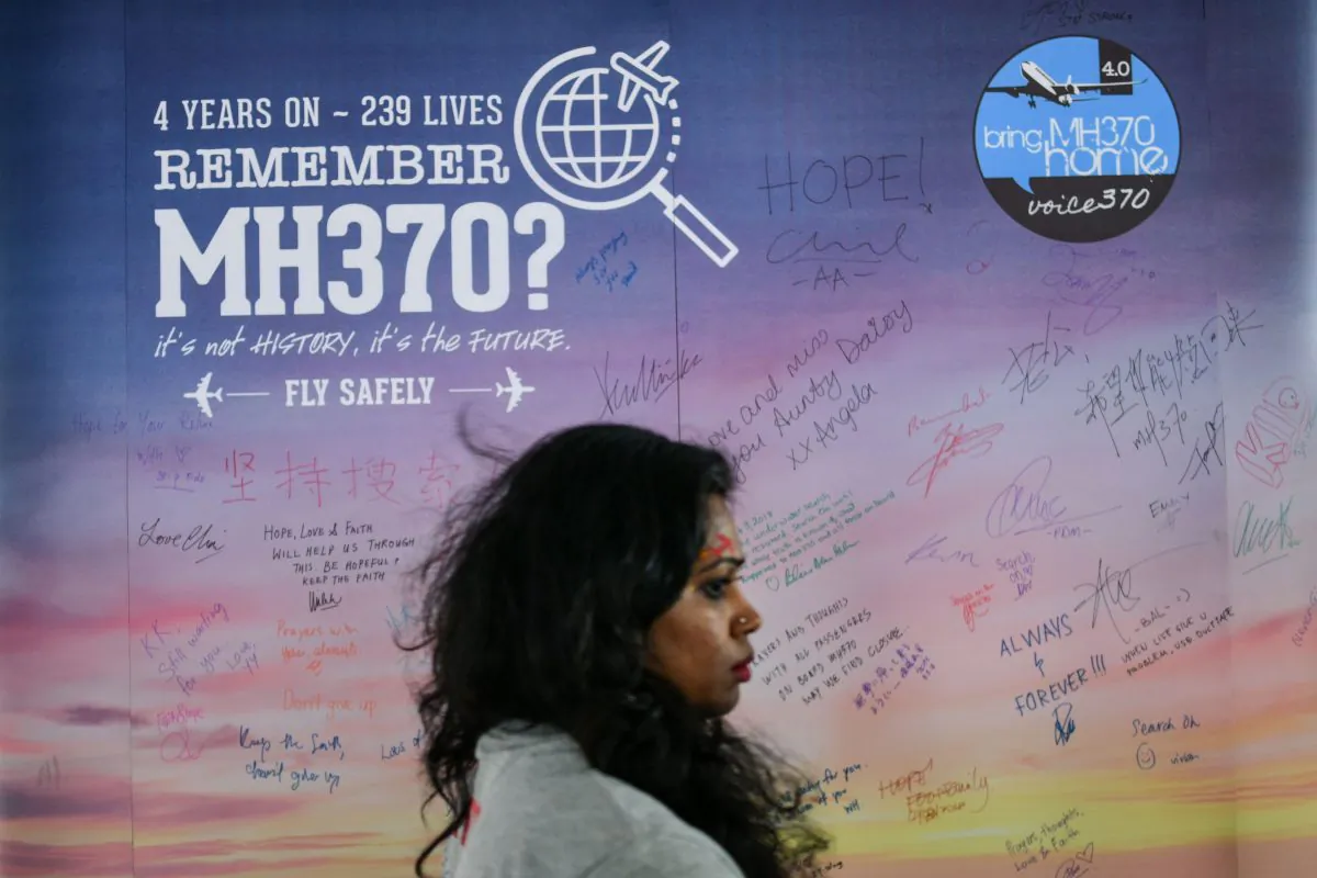 A woman walks past a banner bearing solidarity messages for passengers of the missing Malaysia Airlines flight MH370,  during a memorial event in Kuala Lumpur on March 3, 2018. (Manan Vatsyayana/AFP/Getty Images)
