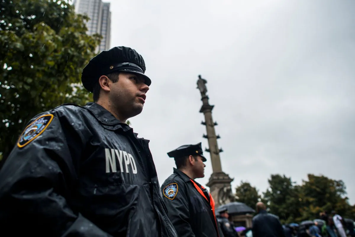 New York Police Department (NYPD) officers on the job. Two officers stand alert near the statue of Christopher Columbus at the Columbus Circle in New York on October 9, 2017, while a small group of people protest calling for the removal of the statue.  (JEWEL SAMAD/AFP/Getty Images)
