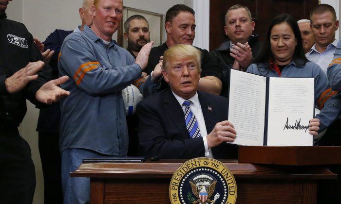 U.S. President Donald Trump holds up a proclamation during a White House ceremony to establish tariffs on imports of steel and aluminum at the White House in Washington on March 8, 2018. (Reuters/Leah Millis) 		