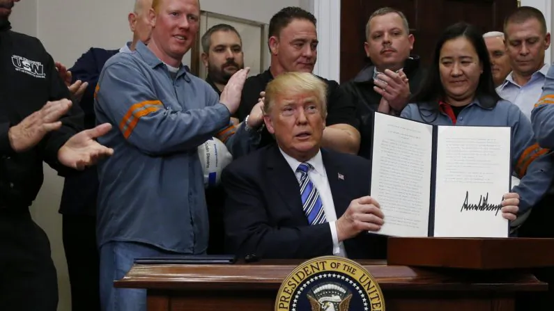 U.S. President Donald Trump holds up a proclamation during a White House ceremony to establish tariffs on imports of steel and aluminum at the White House in Washington, March 8, 2018. (Leah Millis/Reuters)