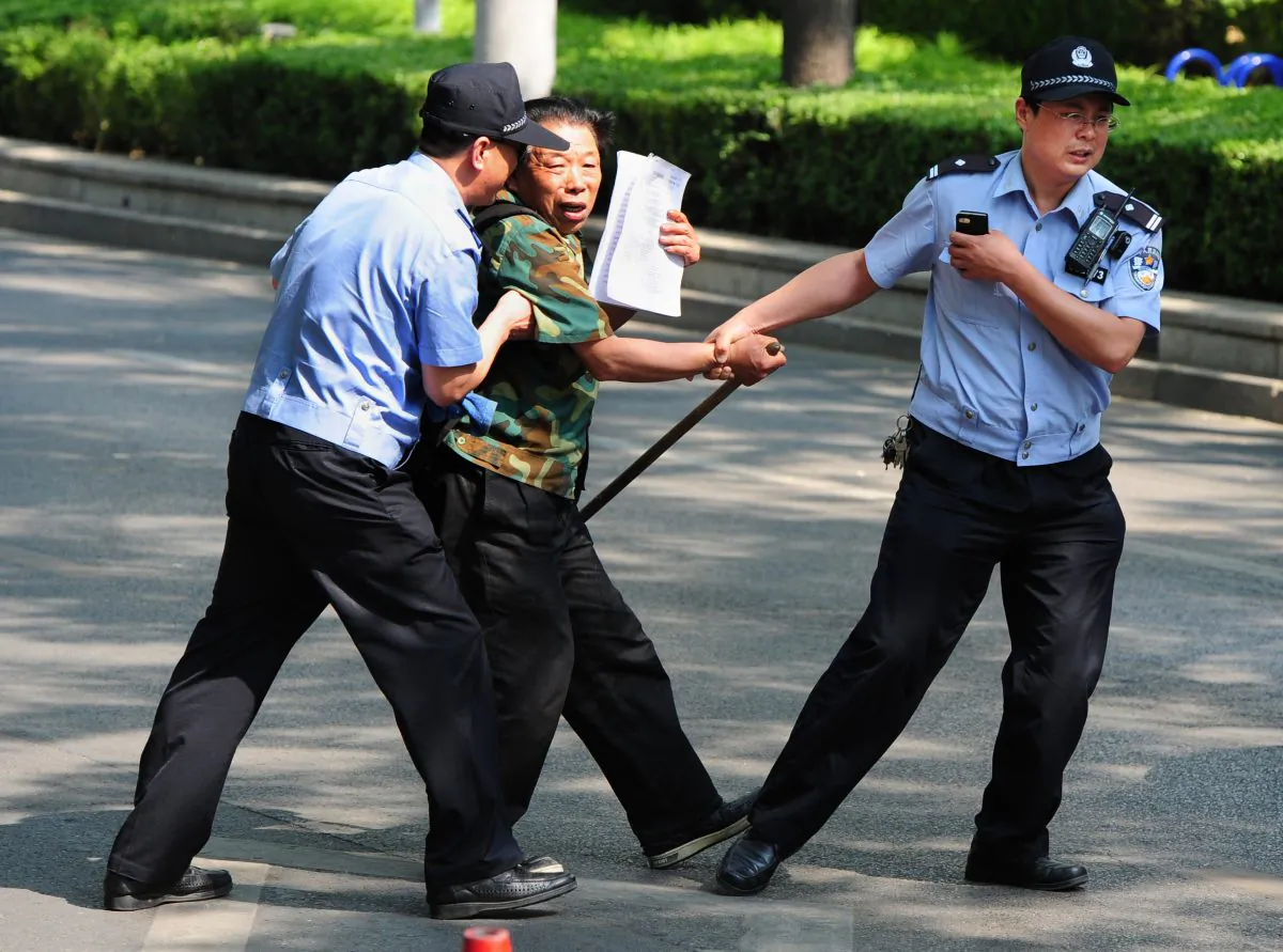 A petitioner is detained by police outside the Chaoyang Hospital where a group of people are protesting about medical and land grab issues in Beijing on May 8, 2012. (Mark Ralston/AFP/GettyImages)