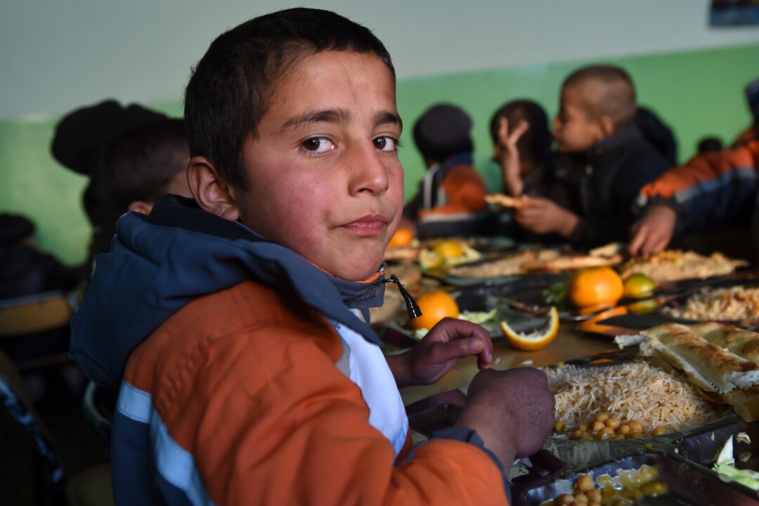 An Afghan orphan looks on as he eats his lunch at the Halwdin government orphanage in Kabul on Dec. 17, 2014. (Wakil Kohsar/AFP/Getty Images)
