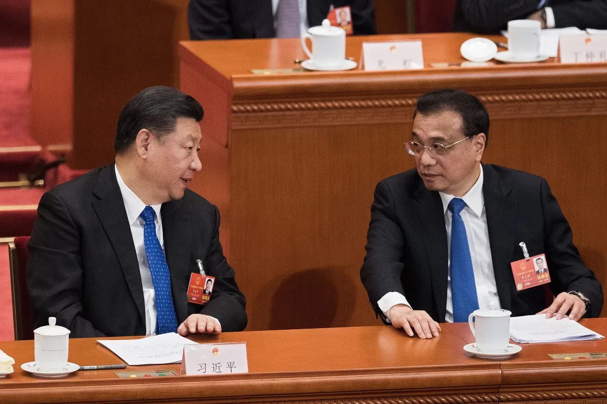 Chinese leader Xi Jinping (L) and Premier Li Keqiang (R) in conversation at a session of the National People's Congress in Beijing on March 13, 2018. (Nicolas Asfouri/AFP/Getty Images)