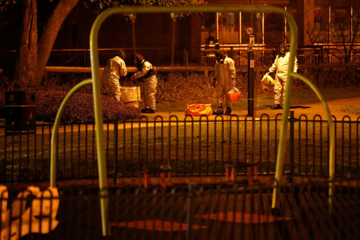 Members of the emergency services wearing protective clothing work next to a children's play area near the bench where former Russian intelligence officer Sergei Skripal and his daughter Yulia were found poisoned in Salisbury, Britain, March 13, 2018. (Reuters/Henry Nicholls)
