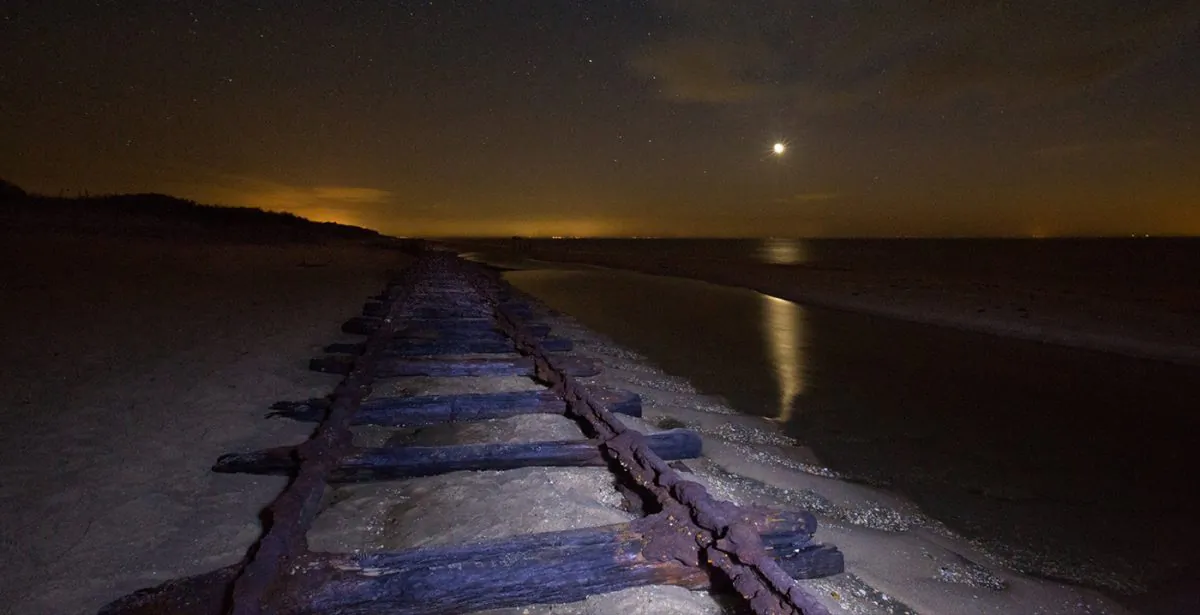Century-old railroad tracks show up on a beach in New Jersey in 2014. (Werner Tedesco)