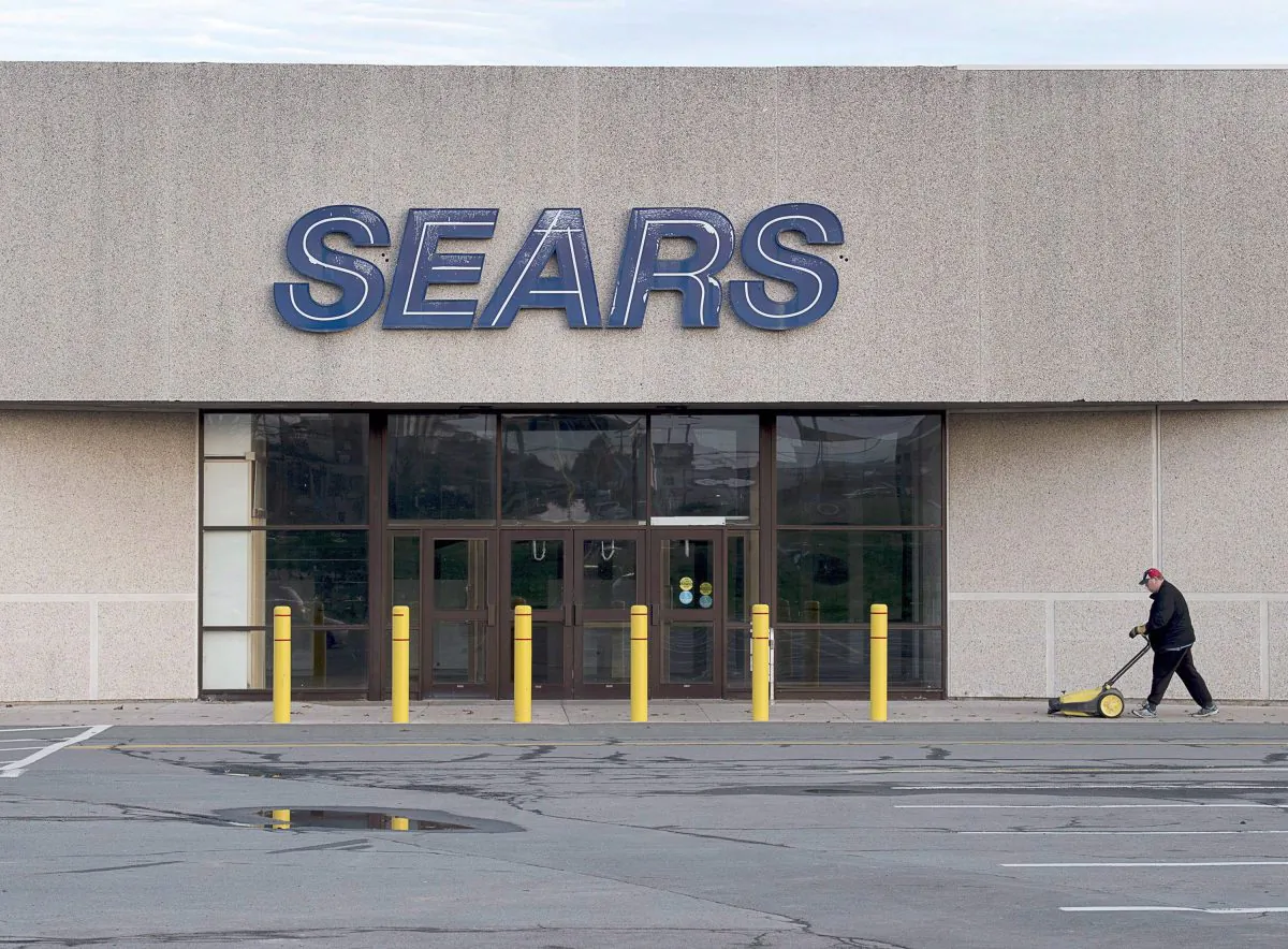 A worker cleans the sidewalk outside a closed Sears store in Dartmouth, N.S. on Oct. 11, 2017. (The Canadian Press/Andrew Vaughan)