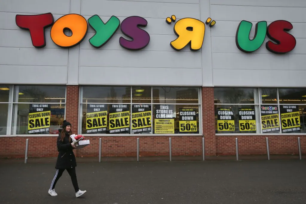 A customer walks out of a Toys r Us store with 'closing down sale' signs in the windows in south London on Feb. 9, 2018. (Daniel Leal-Olivas/AFP/Getty Images)