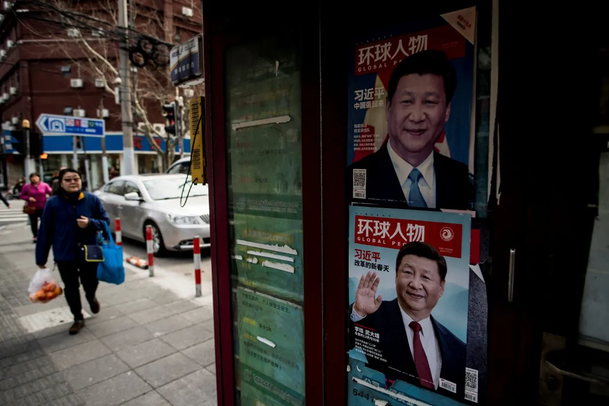 A woman passes a newspaper stand showing a magazine with a picture of Chinese leader Xi Jinping on its cover, in downtown Shanghai, China, on March 12, 2018. (Johannes Eisele/AFP/Getty Images)