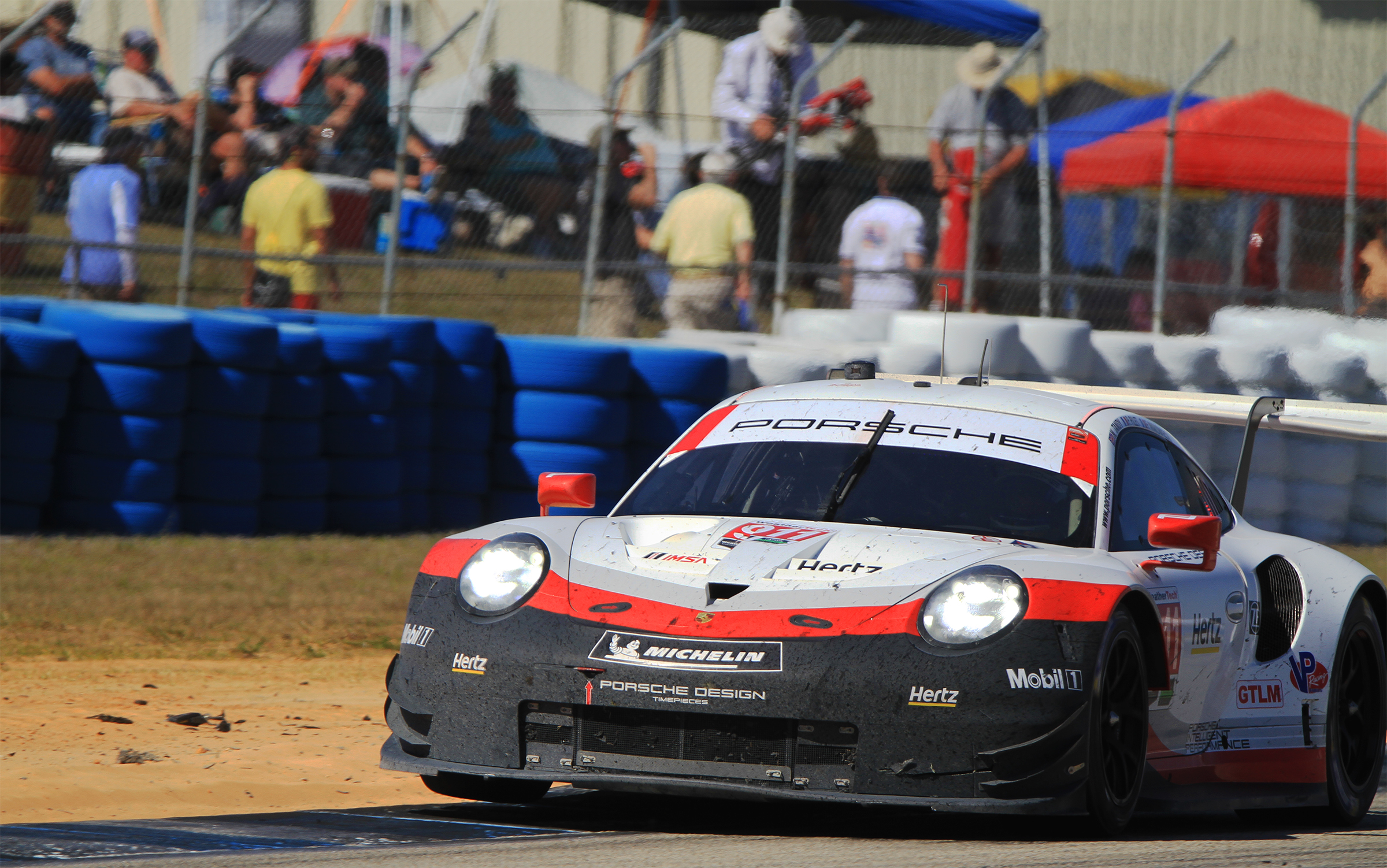 The driver of the #911 Porsche bounces a wheel into the air exiting Turn Five. (Chris Jasurek/Epoch Times)