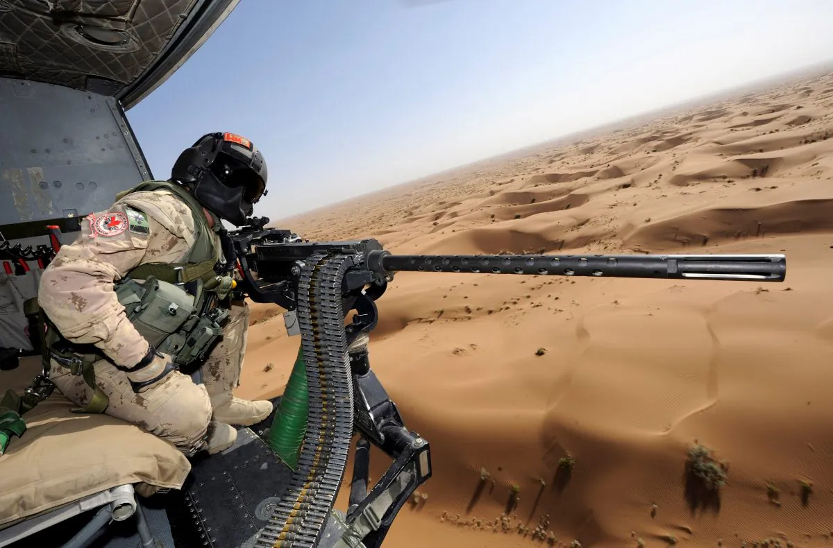 Canadian Forces door gunner Sergeant Chad Zopf leans out of a CH-146 Griffon helicopter during a training exercise in Kandahar district, Afghanistan June 18, 2011. (Sgt Matthew McGregor/Canada Department of National Defence/Handout via Reuters)