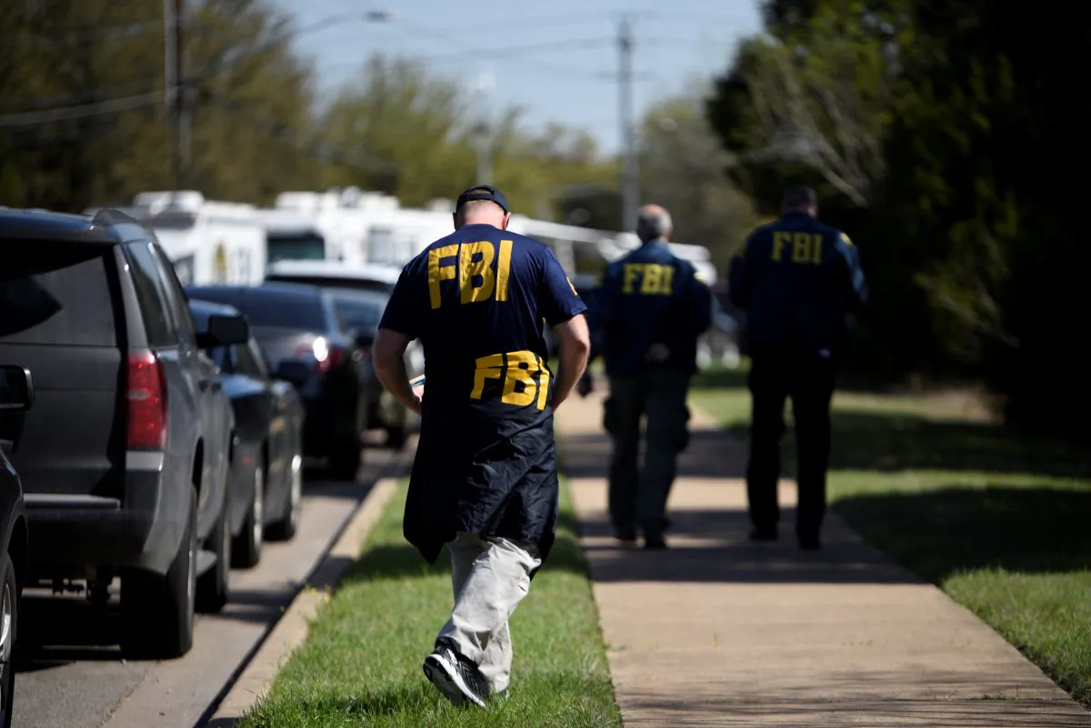 FBI agents walk towards a crime scene on Mission Oaks Boulevard following an explosion in Austin, Texas, U.S., March 19, 2018. (Reuters/Sergio Flores)