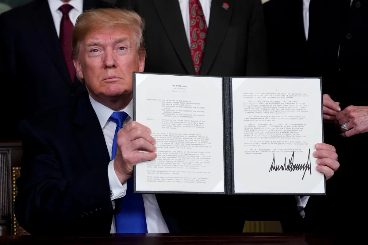 U.S. President Donald Trump holds his signed memorandum on intellectual property tariffs on high-tech goods from China, at the White House in Washington, U.S. on March 22, 2018. (Jonathan Ernst/Reuters)