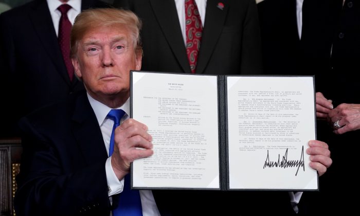 U.S. President Donald Trump holds his signed memorandum on intellectual property tariffs on high-tech goods from China, at the White House in Washington, U.S. on March 22, 2018. (Jonathan Ernst/Reuters)