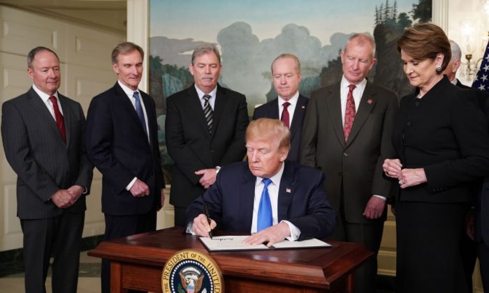 President Donald Trump signs trade sanctions against China in the Diplomatic Reception Room of the White House in Washington, D.C., on March 22, 2018. (Mandel Ngan/AFP/Getty Images)
