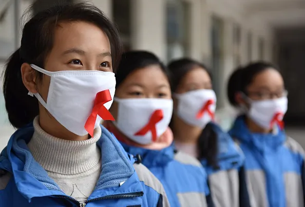 Students of Chaohu No.2 Middle School wear masks with red ribbons in Chaohu City, Anhui Province of China, on November 30, 2017. (Photo by VCG/VCG via Getty Images)