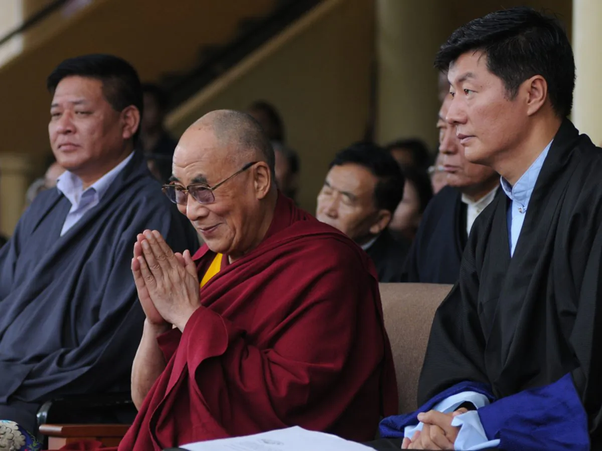 Tibetan spiritual leader the Dalai Lama (C), flanked by President of the Central Tibetan Administration Lobsang Sangay (R) and Speaker of the Tibetan Parliament-in-exile Penpa Tsering (L), greets the audience during the 52nd anniversary of Tibetan Democracy Day at the Tsuglakhang Temple in McLeod Ganj, Dharamsala on Sept. 2, 2012. (STRDEL/AFP/GettyImages)