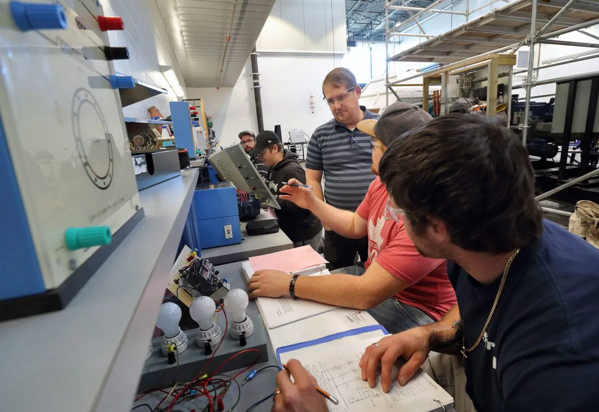 Colin Winder, instructor of the wind turbine technician program at Lethbridge College, provides practical training for students on Nov. 15, 2017, in Lethbridge, Alberta. Unpredictable physical work is less vulnerable to automation. (The Canadian Press/David Rossiter)