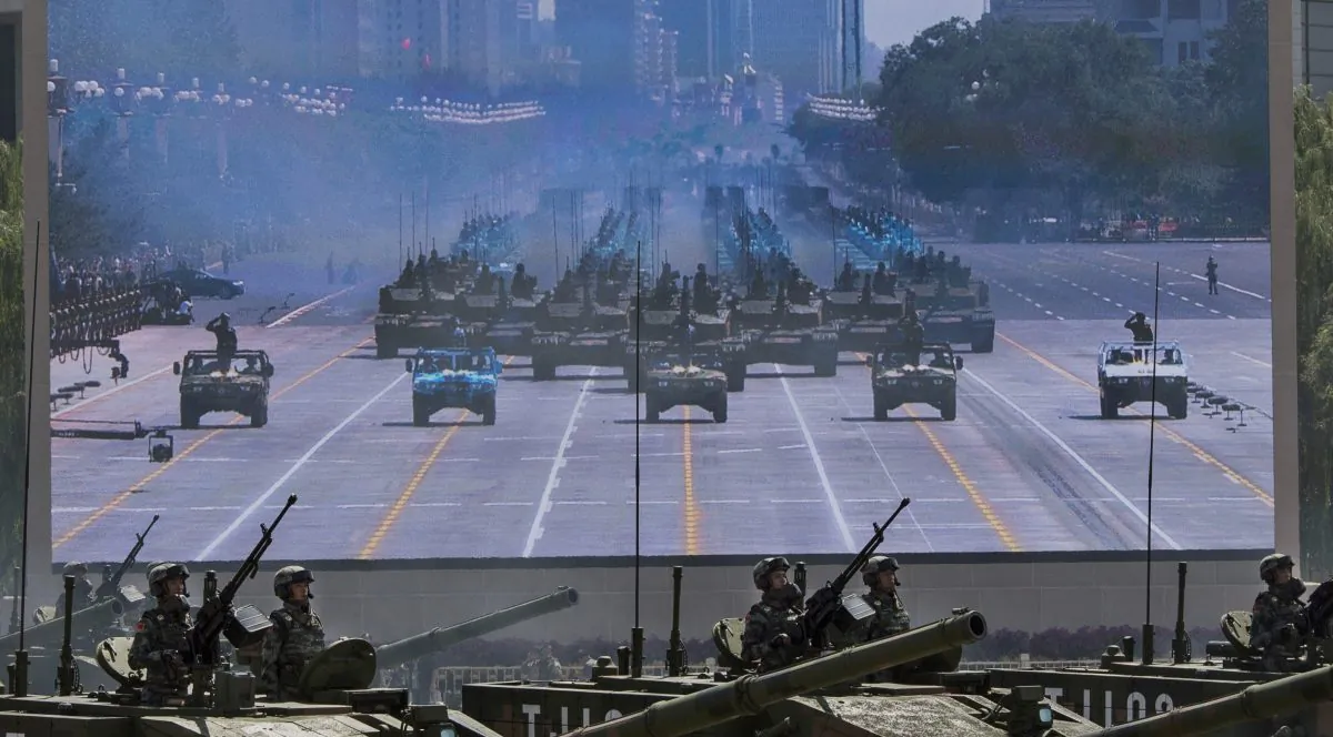 Soldiers in tanks pass in front of a screen near Tiananmen Square during a military parade in Beijing on Sept. 3, 2015. (Kevin Frayer/Getty Images)