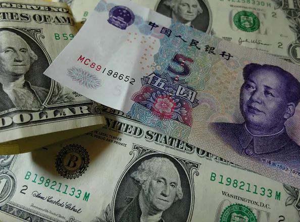 Yuan banknotes and US dollars are seen on a table in Yichang, central China's Hubei province on August 14, 2015. (STR/AFP/Getty Images)