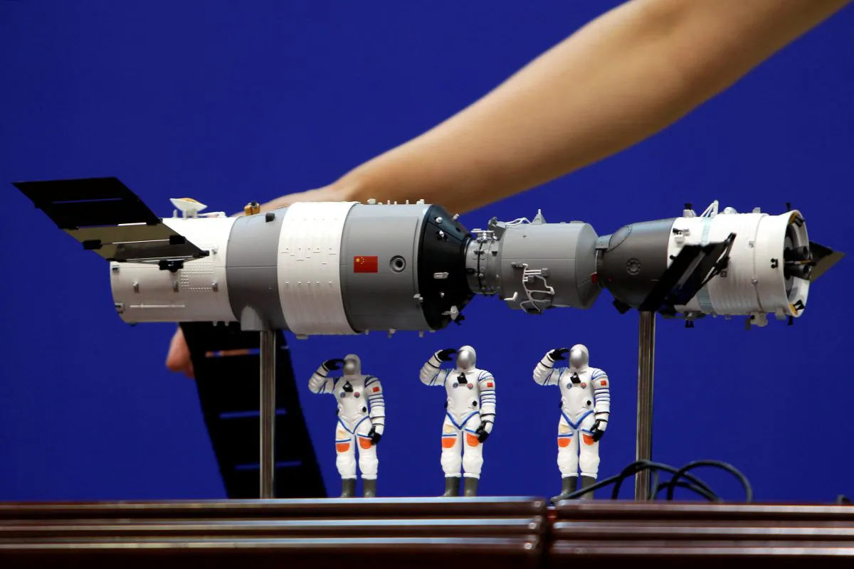A model of the Tiangong-1 space lab module (L), the Shenzhou-9 manned spacecraft (R) and three Chinese astronauts is displayed during a news conference at Jiuquan Satellite Launch Center, in Gansu province, China June 15, 2012. (Reuters/Jason Lee/File Photo)