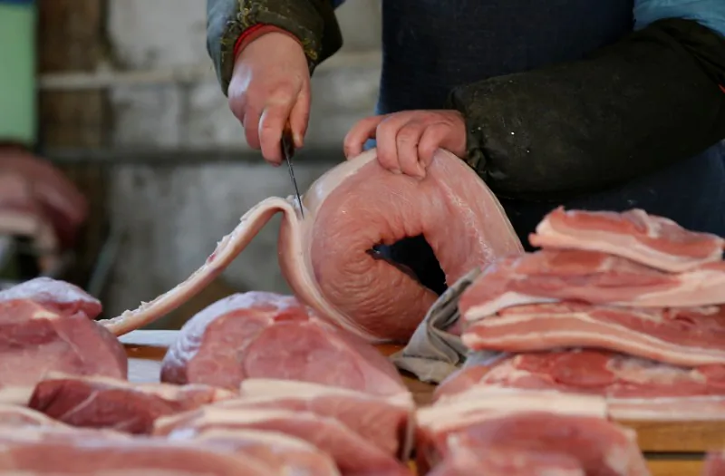 A butcher cuts a piece of pork at a market in Beijing, China, March 25, 2016 (Reuters/Jason Lee/File Photo)