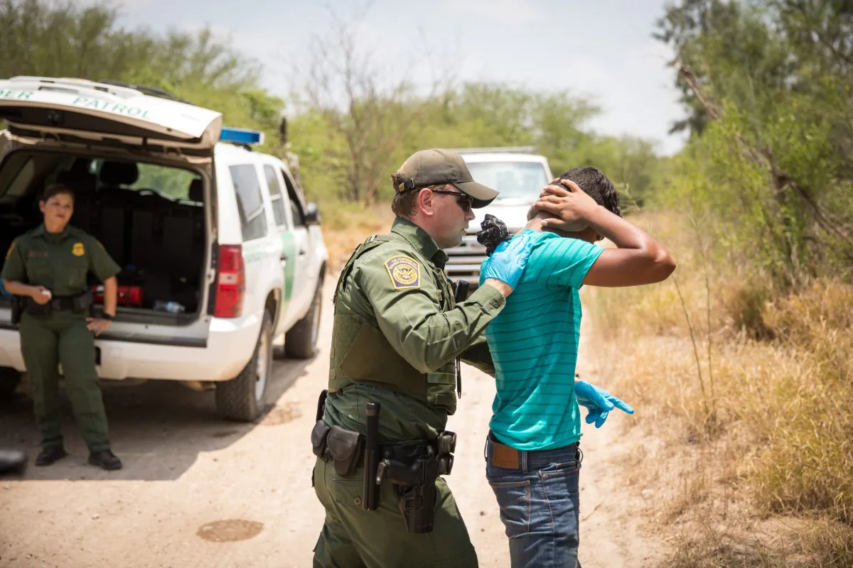 A Border Patrol agent pats down a man who crossed the Rio Grande River from Mexico into the United States in Hidalgo County, Texas, on May 26, 2017. (Benjamin Chasteen/The Epoch Times)