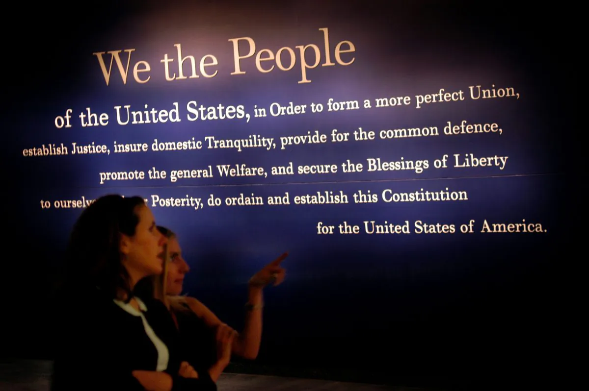 Two women walk past a painting of the beginning of the U.S. Constitution during a preview of the National Constitution Center in Philadelphia, Penn., on July 1, 2003.  William Thomas Cain/Getty Images