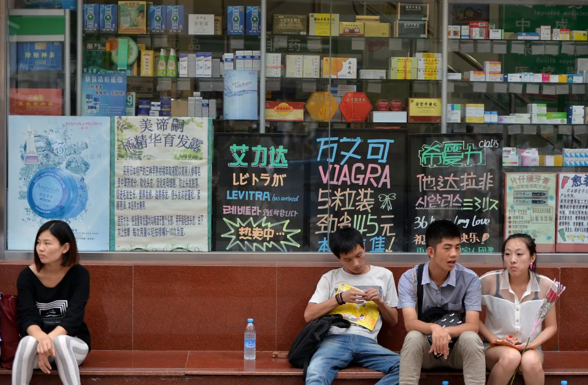 Chinese shoppers wait outside a pharmacy in Beijing, China, on Aug. 13, 2013. China imposes high tariffs on imported medicines, which has made it difficult for many citizens to afford treatment for their illnesses. (Mark Ralston/AFP/Getty Images)