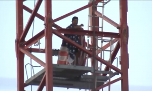 Barefoot Man Balances Atop 200-Foot Crane Draped in American Flag—And There's Mystery Behind It