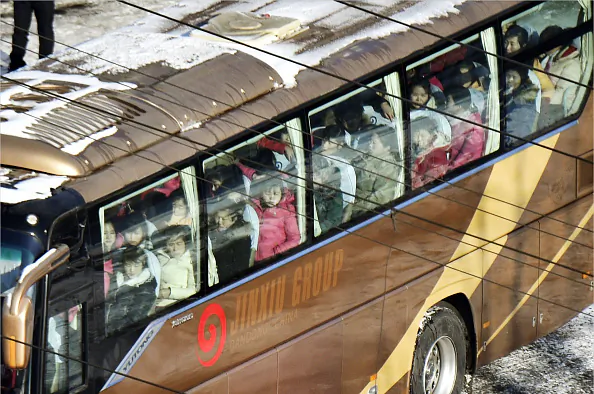 North Korean workers board a bus at customs in Dandong, China's border city with North Korea, on Jan. 9, 2018. 
(Kyodo News via Getty Images)