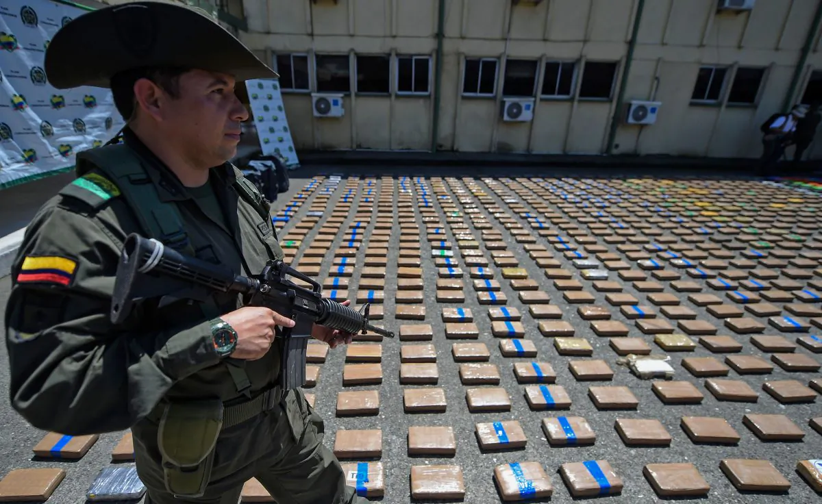A member of the Colombian antinarcotics police, stands guard beside a one-ton shipment of cocaine seized to the country's biggest drug gang, the Gulf Clan in a container with destination to Europe in Buenaventura, Colombia's main port on the Pacific Ocean, on Aug. 10, 2017. (RAUL ARBOLEDA/AFP/Getty Images)