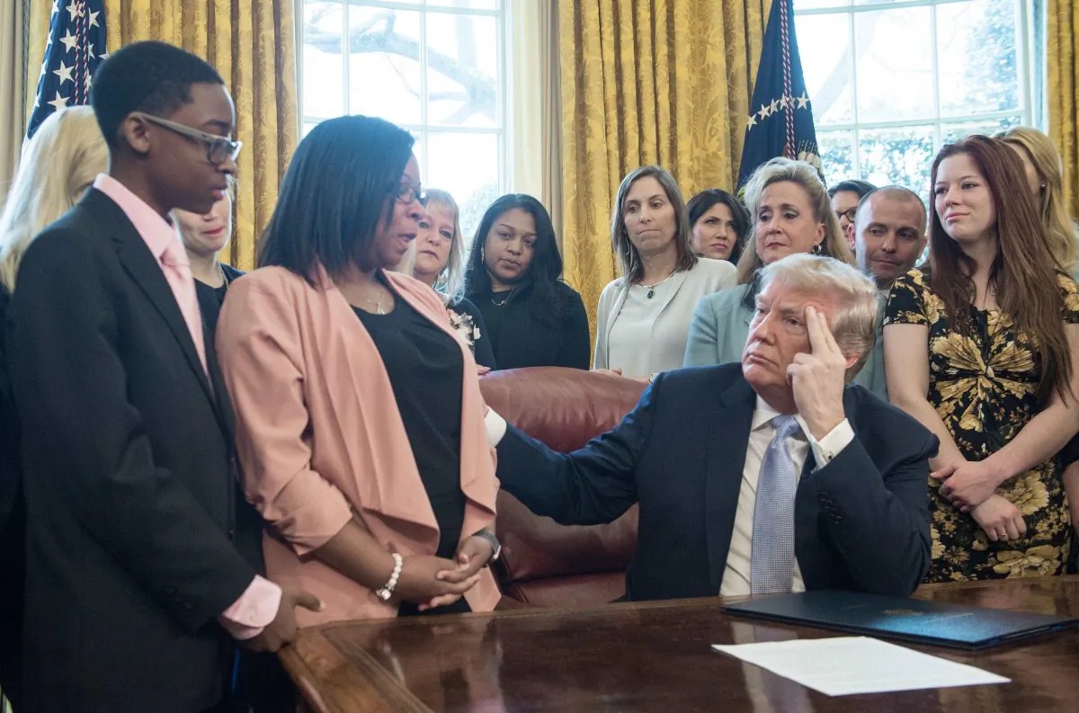 US President Donald Trump listens to Yvonne Ambrose, whose 16-year old daughter was murdered, before signing the Allow States and Victims to Fight Online Sex Trafficking Act of 2017 in the Oval Office at the White House in Washington, DC, on April 11, 2018. (NICHOLAS KAMM/AFP/Getty Images)