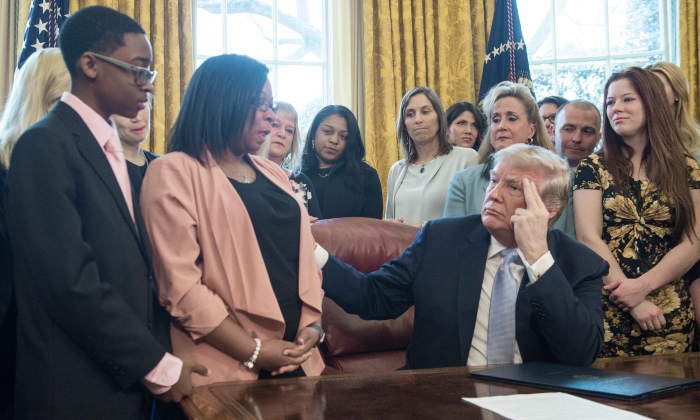 US President Donald Trump listens to Yvonne Ambrose, whose 16-year old daughter was murdered, before signing the Allow States and Victims to Fight Online Sex Trafficking Act of 2017 in the Oval Office at the White House in Washington, DC, on April 11, 2018. (NICHOLAS KAMM/AFP/Getty Images)