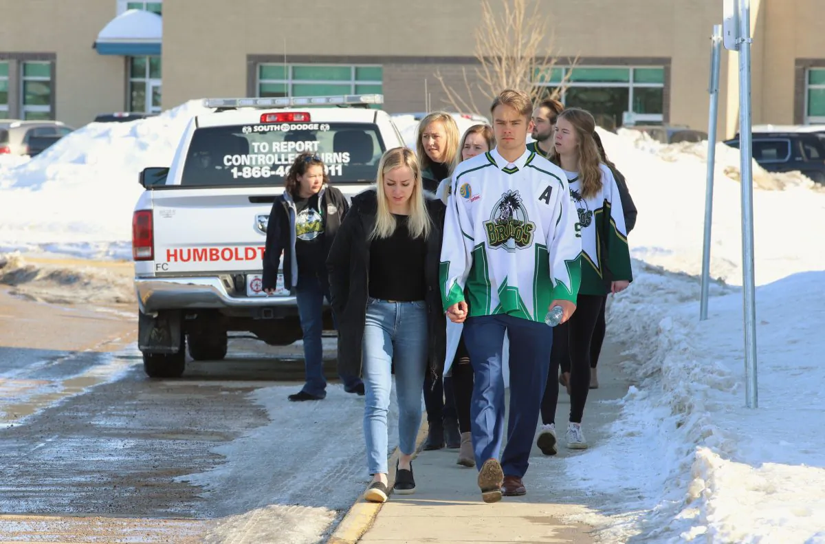 People, including a young man wearing a Humboldt Broncos jersey, approach the Uniplex on April 8, 2018 in Humboldt, Canada, prior to a memorial vigil for the Humboldt Broncos ice hockey team. (Kymber Rae/AFP/Getty Images)