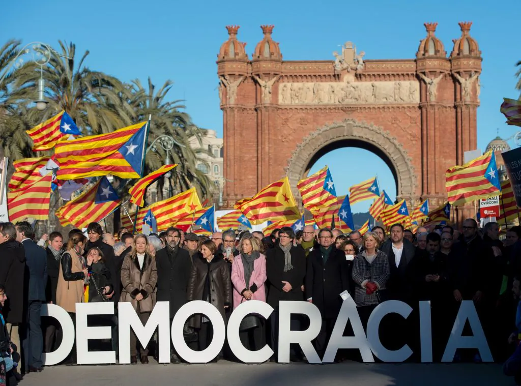 TOPSHOT - Former President of the Catalan Government and leader of Partit Democrata Europeu Catala (Catalan European Democratic Party) PDECAT Artur Mas (between R and A letters) poses with other members of Catalan Government, the Catalan Parliament, Catalan mayors and party members few moments before his arrival at the TSJC (Superior Court of Catalonia) in Barcelona on Feb. 6, 2017.
(Photo credit should read JOSEP LAGO/AFP/Getty Images)