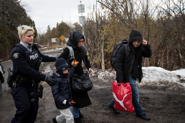HEMMINGFORD, QUEBEC - FEBRUARY 23: A family of three is escorted to a police vehicle by a Royal Canadian Mounted Police officer after they illegally crossed the U.S.-Canada border into Canada, February 23, 2017 in Hemmingford, Quebec. In the past month, hundreds of people have crossed Quebec land border crossings in attempts to seek asylum and claim refugee status in Canada. (Photo by Drew Angerer/Getty Images)