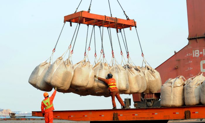 Workers unload goods from a ship at the port in Lianyungang, east China's Jiangsu province on Feb. 12, 2014. China's trade surplus rose 14.0 percent year-on-year in Jan. to 31.86 billion USD, official figures showed as exports increased 10.6 percent to 207.13 billion USD, while imports were up 10.0 percent to 175.27 billion USD, the General Administration of Customs said.    (Photo credit should read STR/AFP/Getty Images)