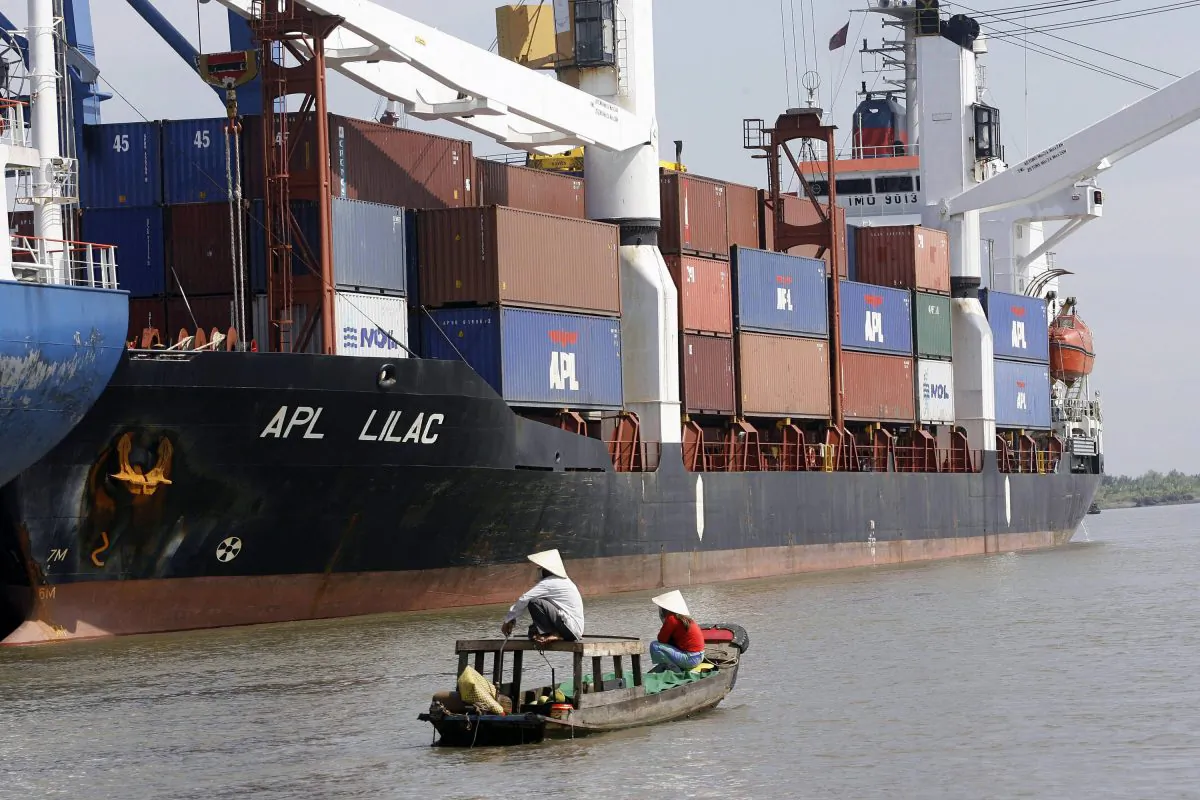 A sampan passes a container port in Ho Chi Minh City, Vietnam, on Dec. 21, 2006. (Hoang Dinh Nam/AFP/Getty Images)
