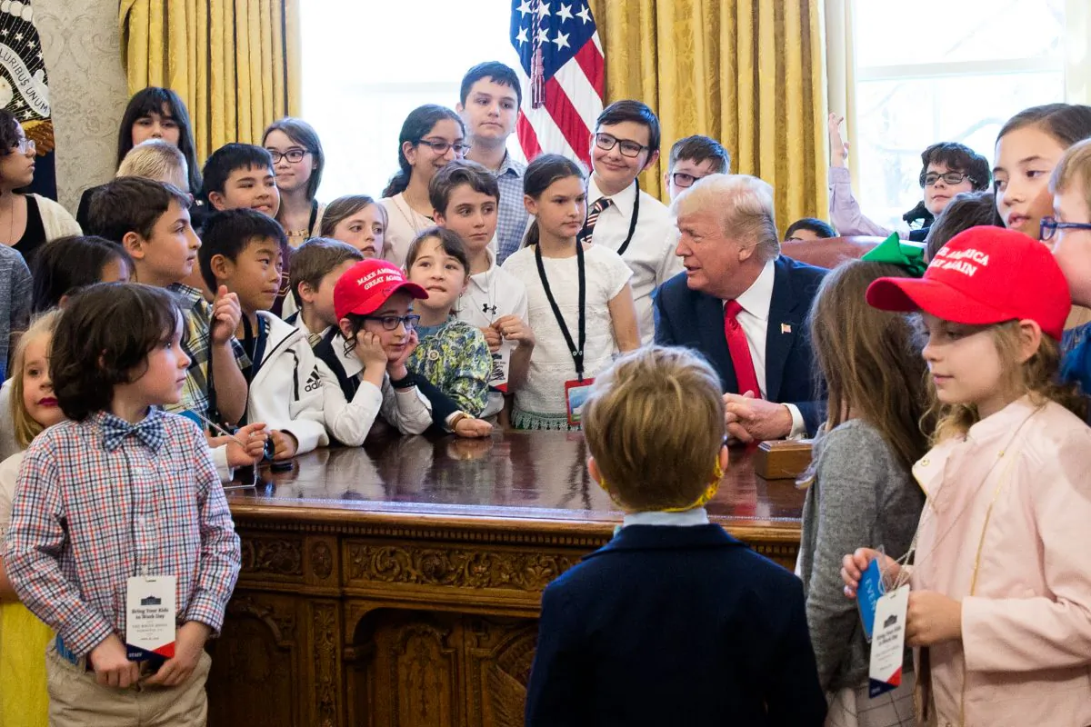 President Donald Trump is surrounded by the children of press and staff  during 'Take your Daughters and Sons to Work Day' in the Oval Office in Washington on April 26, 2018. (Samira Bouaou/The Epoch Times)