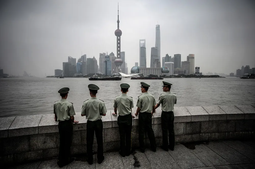 Paramilitary policemen stand in front of the skyline of the Lujiazui Financial District in Pudong in smog in Shanghai on Sept. 29, 2014. (JOHANNES EISELE/AFP/Getty Images)