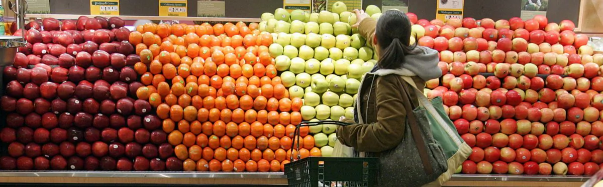 A woman selects apples while shopping in the produce section at Whole Foods January 13, 2005 in New York City.  (Photo by Stephen Chernin/Getty Images)
