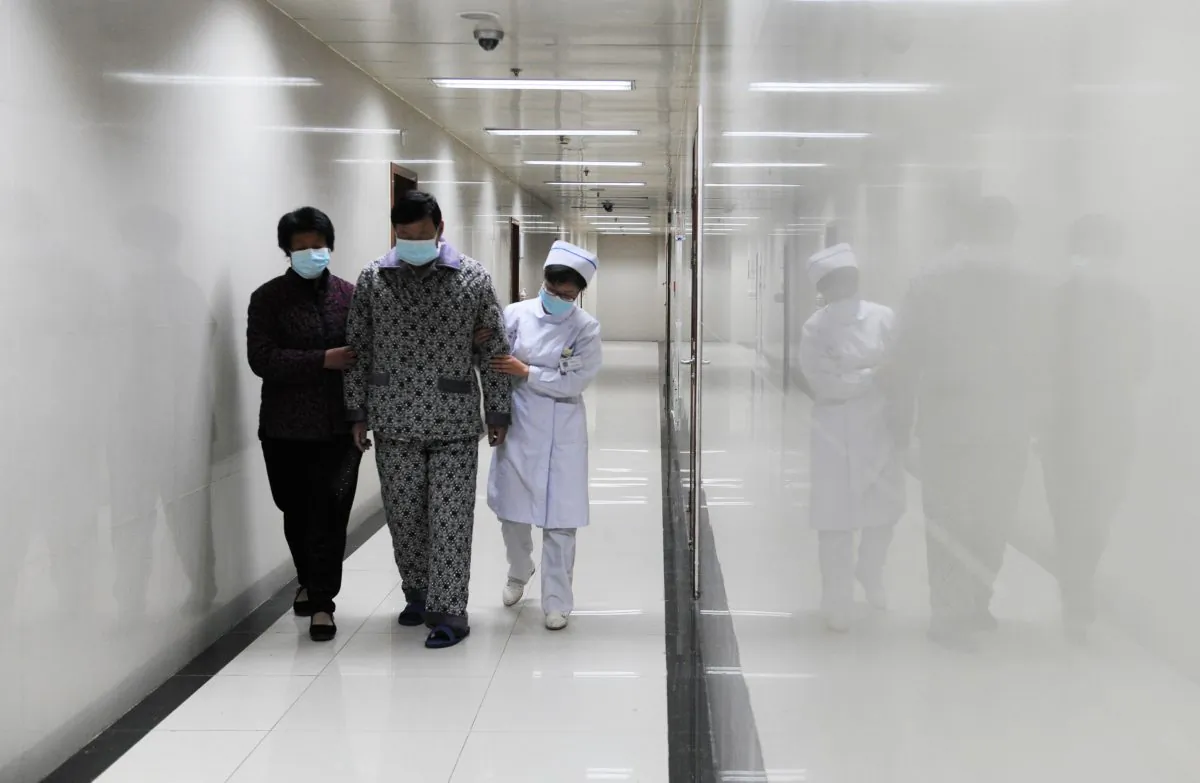 An H7N9 bird flu patient walks in the corridor of a hospital in Bozhou City, in central China's Anhui Province on April 19, 2013. A recent Chinese Communist Party internal investigation has found rampant corruption within the province's medical system. (STR/AFP/Getty Images)