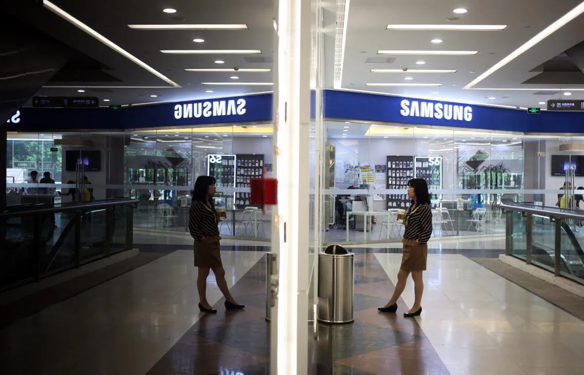 A woman waits for an elevator near a Samsung store in Beijing on May 8, 2015. (Greg Baker/AFP/Getty Images)