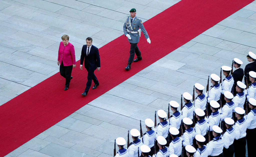 German Chancellor Angela Merkel and French President Emmanuel Macron arrive at a ceremony at the Chancellery in Berlin, Germany, May 15, 2017.    (REUTERS/Hannibal Hanschke)