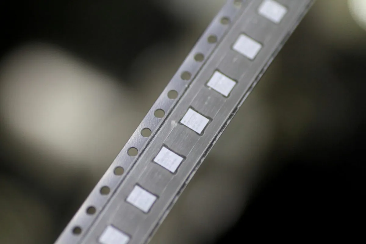 Microchips emerge from a machine onto a roll in the clean room at the UTAC plant in Singapore, on Feb. 8, 2018. (Thomas White/File Photo/Reuters)