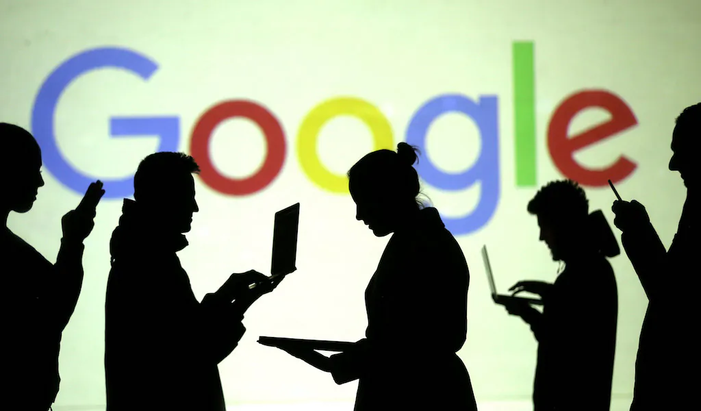 FILE PHOTO: Silhouettes of laptop and mobile device users are seen next to a screen projection of Google logo in this picture illustration taken March 28, 2018.  (REUTERS/Dado Ruvic/Illustration)