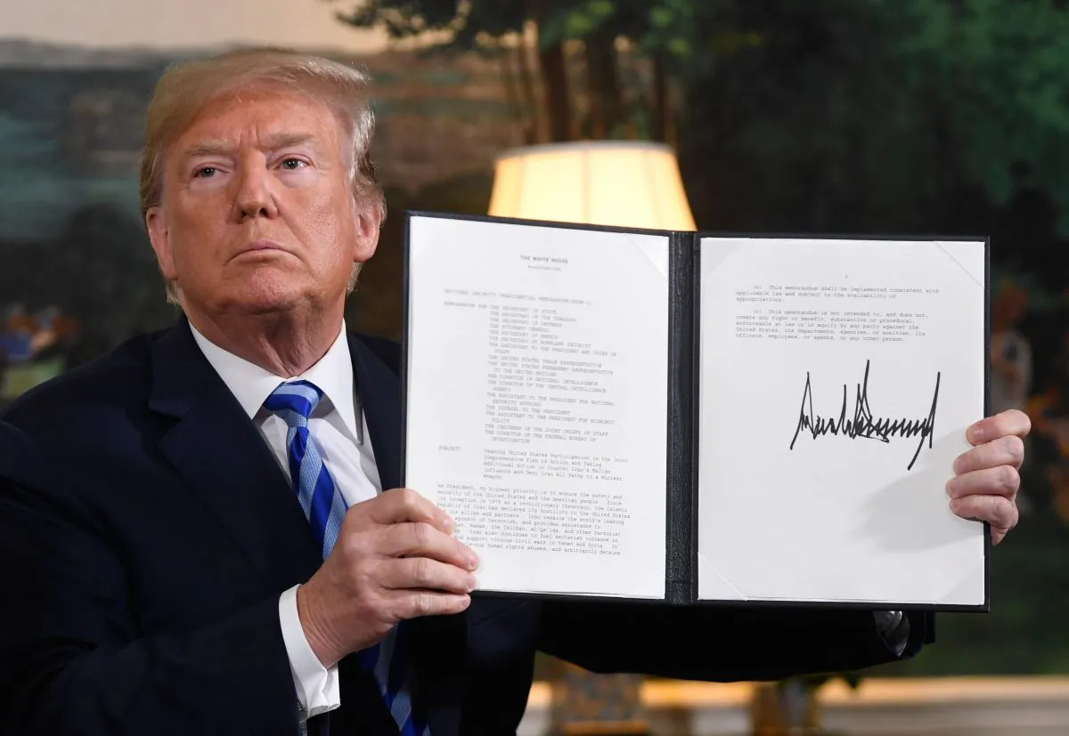 President Donald Trump signs a document reinstating sanctions against Iran after announcing the US withdrawal from the Iran Nuclear deal, in the Diplomatic Reception Room at the White House in Washington, on May 8, 2018. (Saul Loeb/AFP/Getty Images)