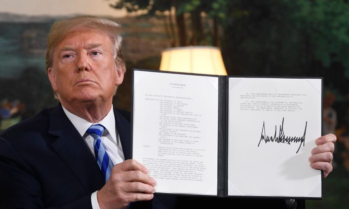 President Donald Trump signs a document reinstating sanctions against Iran after announcing the US withdrawal from the Iran Nuclear deal, in the Diplomatic Reception Room at the White House in Washington,  on May 8, 2018. (Saul Loeb/AFP/Getty Images)