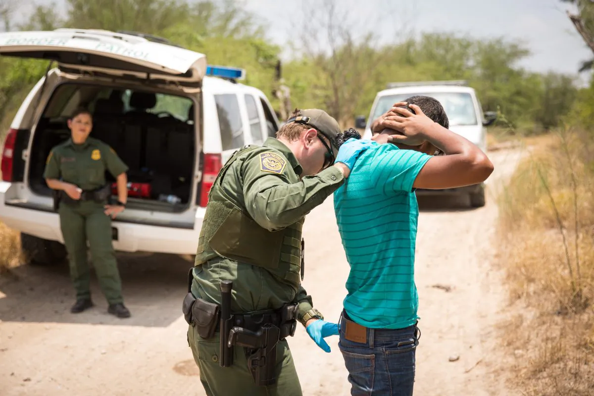 A Border Patrol Agent pats down a man who illegally crossed the Rio Grande from Mexico into the United States in Hidalgo County, Texas, on May 26, 2017. (Benjamin Chasteen/The Epoch Times)
