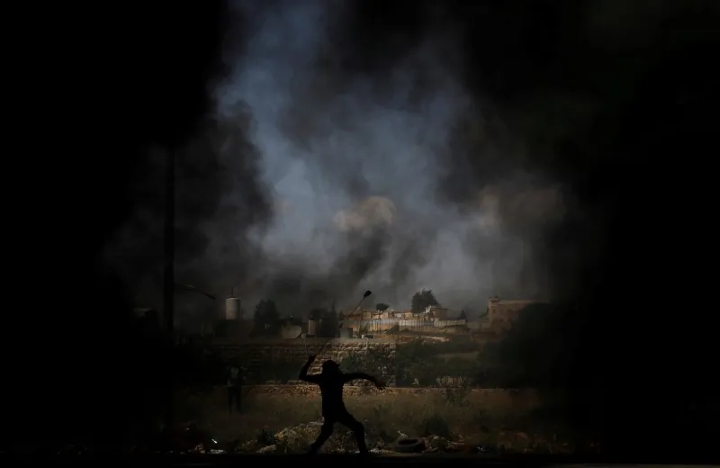 A Palestinian demonstrator uses a sling to hurl stones at Israeli troops during a protest ahead of the 70th anniversary of Nakba, near the Jewish settlement of Beit El, near Ramallah, in the occupied West Bank May 11, 2018. (Reuters/Mohamad Torokman)
